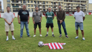 varias persoas posan no campo Martinez Otero de Foz, detrás dunha camiseta do CD Foz, despois das melloras no céspede